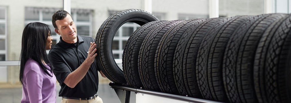 Subaru service representative showing customer a tire. | Subaru of Columbia in Columbia MO