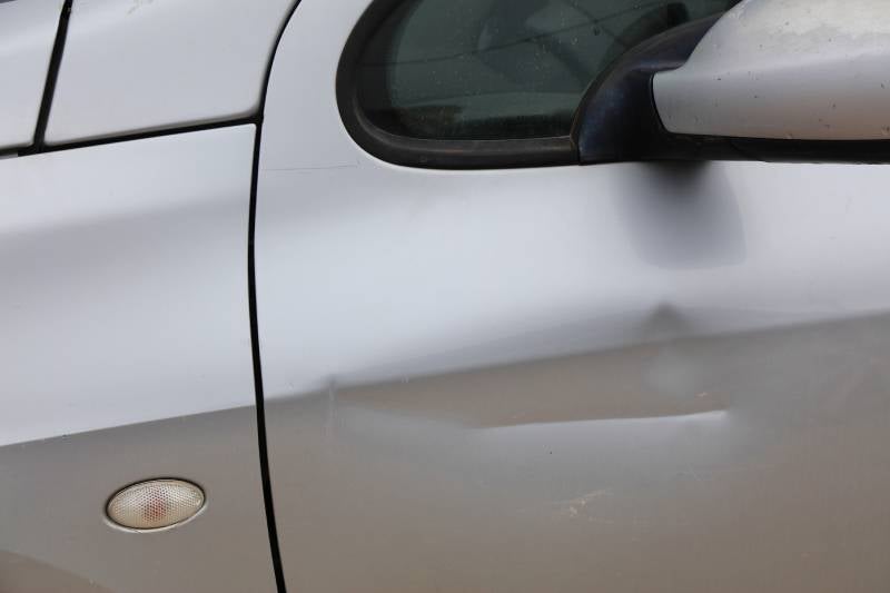 Close-up of minor dent on vehicle door panel